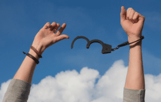 Weniger Pornos. Hände nach oben gestreckt. Frei von Handschellen.