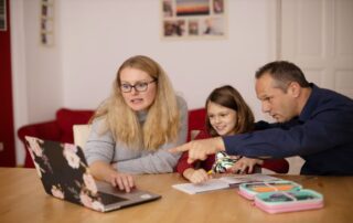 Newsletter. Familie am Tisch mit Laptop