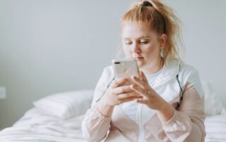 Paul Plener. Mädchen mit Smartphone im Bett